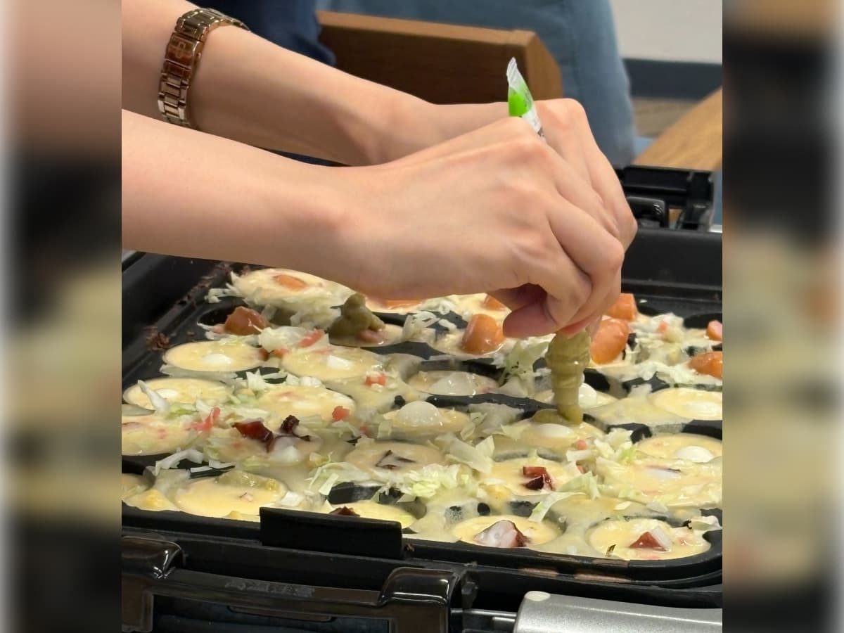 たこ焼きにわさびを入れている様子。